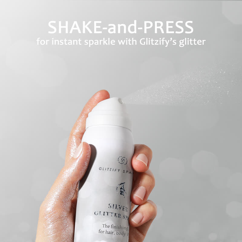 A hand spraying Glitzify silver glitter spray